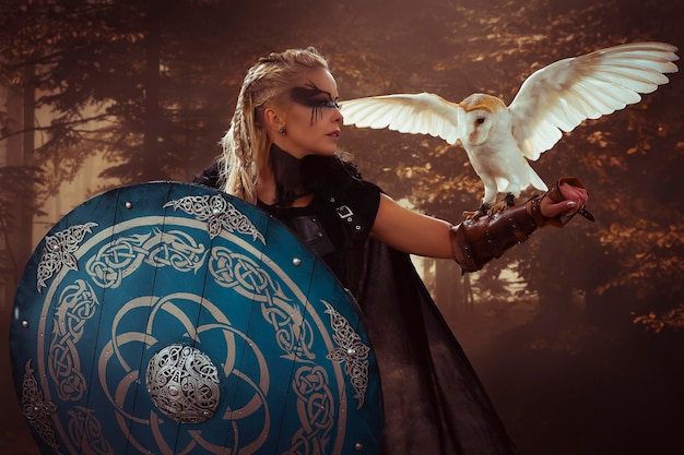 Guerrera, hermosa lechuza blanca, mujer vikinga rubia con escudo y espada, trenzas en el pelo.