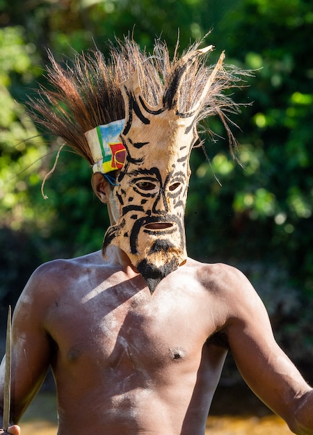 Foto guerrero de la tribu asmat con máscara de batalla.