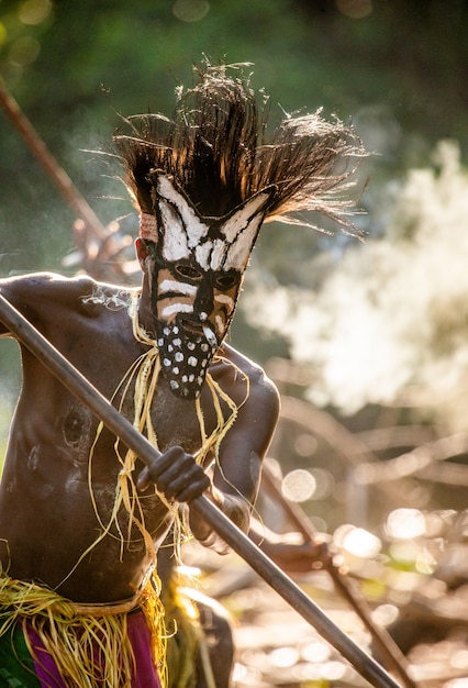 Foto guerrero de la tribu asmat con máscara de combate.