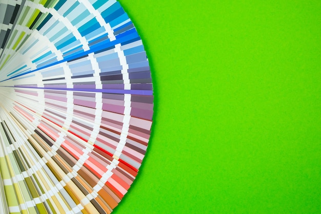 Guia de cores close-up Variedade de flores para design Ventilador de paleta de cores em fundo verde Um designer gráfico seleciona cores de um guia de paleta de cores Catálogo de amostras de cores