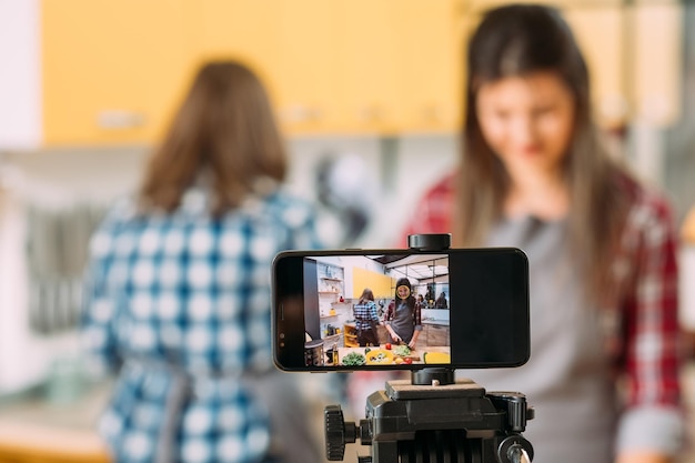 Foto guía de estilo de vida saludable video blog de comida casera dos mujeres trabajando en la cocina compartiendo su experiencia culinaria