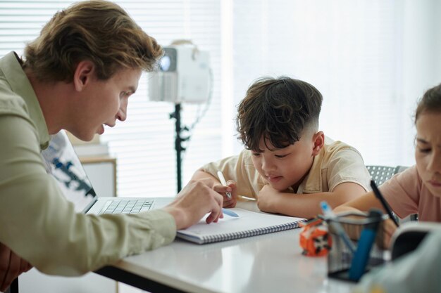 Guiando al niño con la tarea en el escritorio del aula