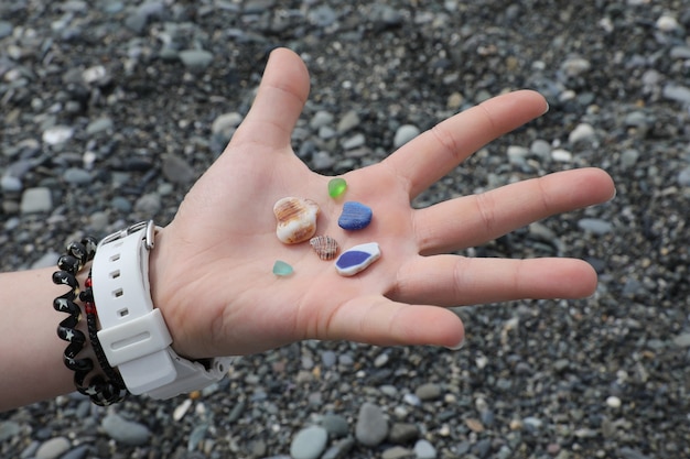 Guijarros de colores en la palma de tu mano recogidos en la playa