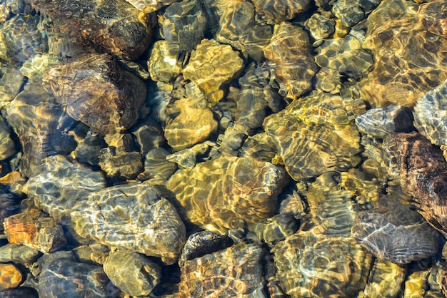 Guijarros de río de fondo bajo una capa de agua clara