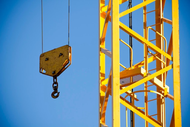 Guindaste amarelo contra o céu azul, torre com gancho