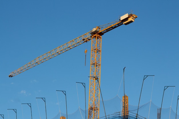 Guindaste de construção amarelo em um fundo azul profundo