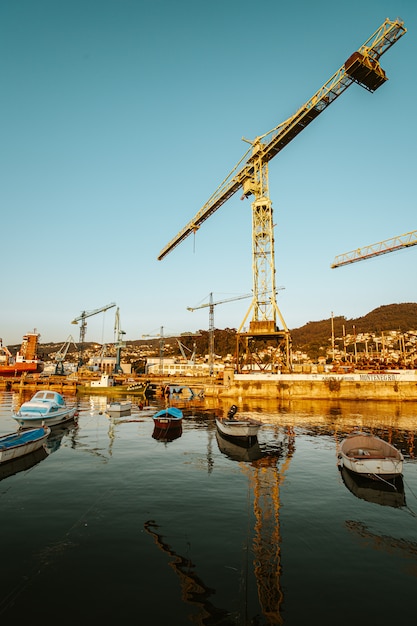 Foto guindaste de construção amarelo maciço perto do mar