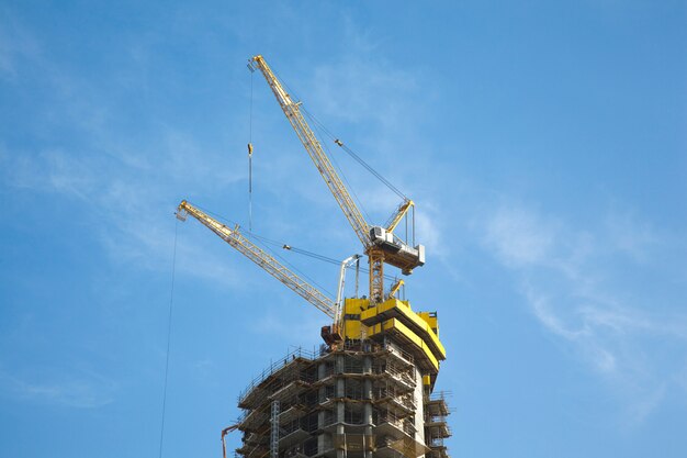 Guindaste de construção na torre contra o céu azul