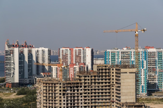 Guindaste de torre de construção amarelo na perspectiva de edifícios residenciais de vários apartamentos sob