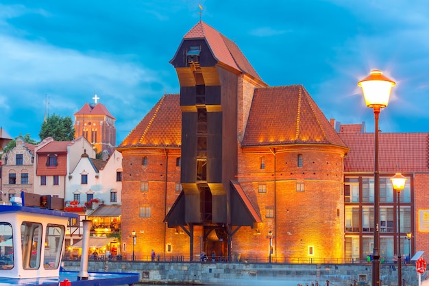 Guindaste do porto antigo e portão da cidade Zuraw na cidade velha de Gdansk à noite, Polônia