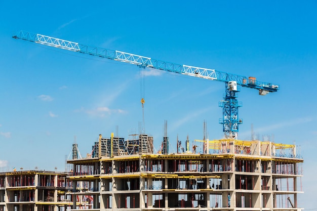 Guindaste e canteiro de obras contra o céu azul