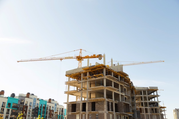 Guindaste e canteiro de obras contra o céu azul