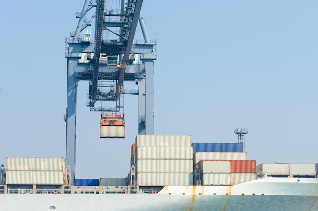 Foto guindaste emprestando contêiner de carga para navio porta-contêineres no conceito de porto de terminal internacional transporte de carga por navio