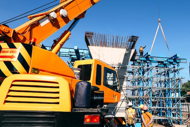 Guindaste industrial elevando estrutura de aço em mega canteiro de obras