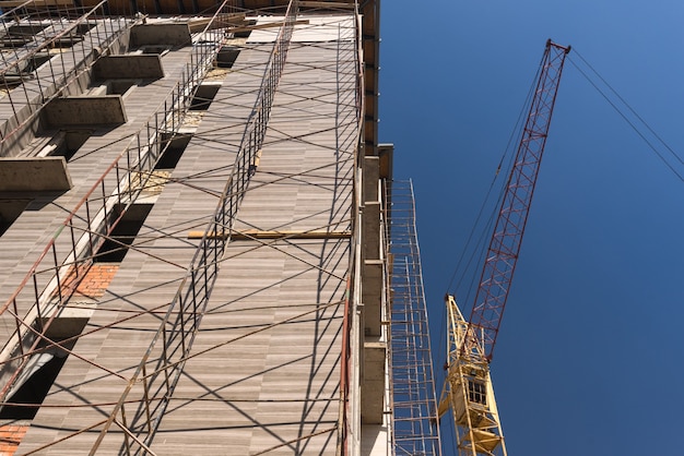 Foto guindaste no fundo do prédio em construção