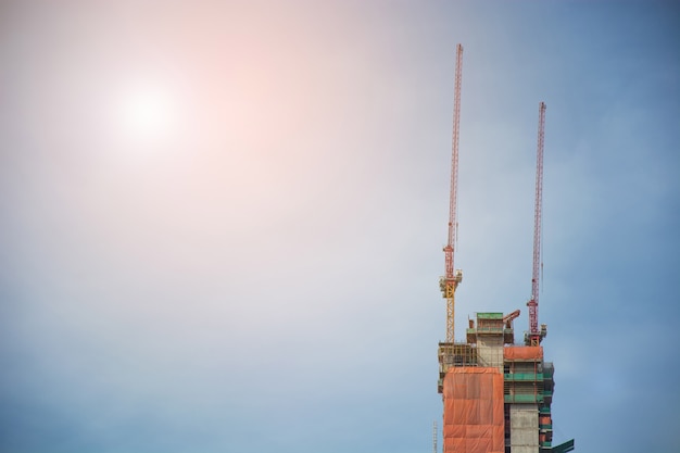 guindastes de construção em edifícios altos com fundo do céu.