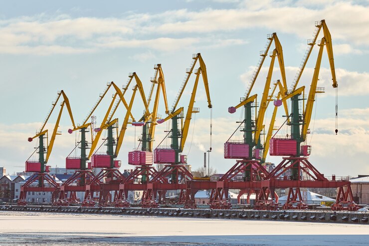 Foto guindastes de porto maciço no porto. guindastes portuários para cargas pesadas, pátio de contêineres de carga, terminal de navios porta-contêineres. negócios e comércio, logística. cena industrial de inverno.