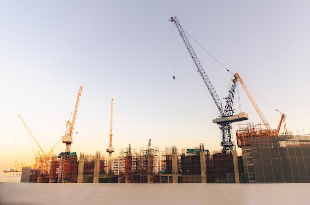 Foto guindastes em um canteiro de obras na cidade contra um céu claro