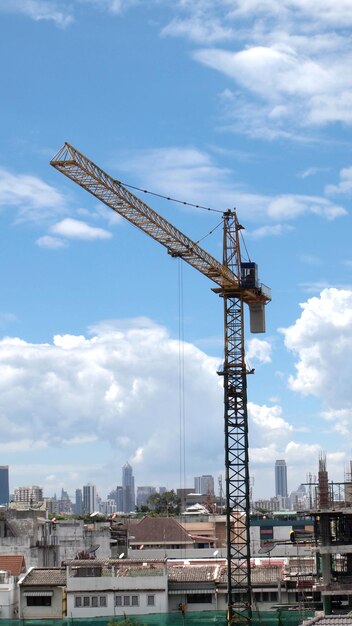 Guindastes no canteiro de obras contra o céu na cidade