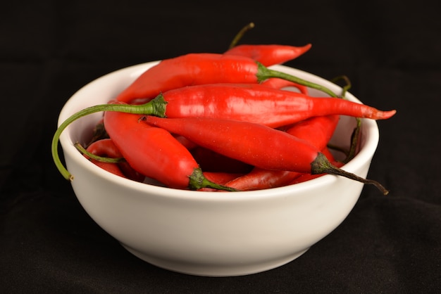 Guindilla caliente en una olla de cerámica blanca con negro