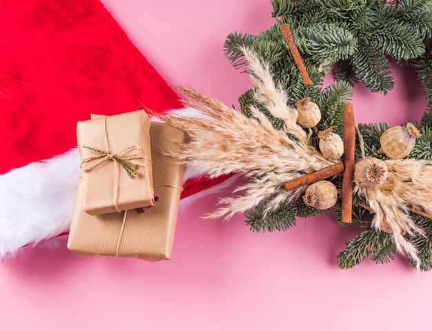 Guirlanda de abeto de boné de papai noel e presentes de natal embrulhados