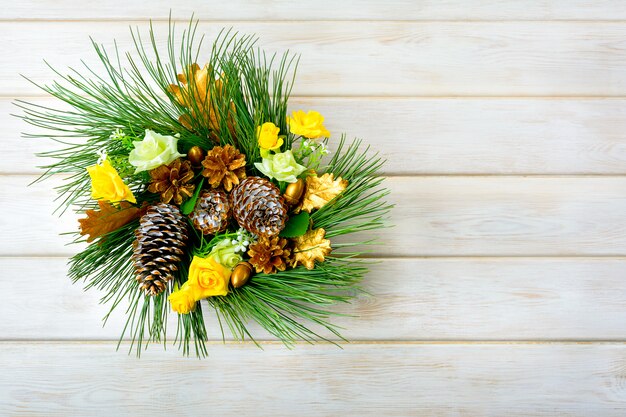 Guirlanda de natal com rosas de seda amarelas e pinhas douradas