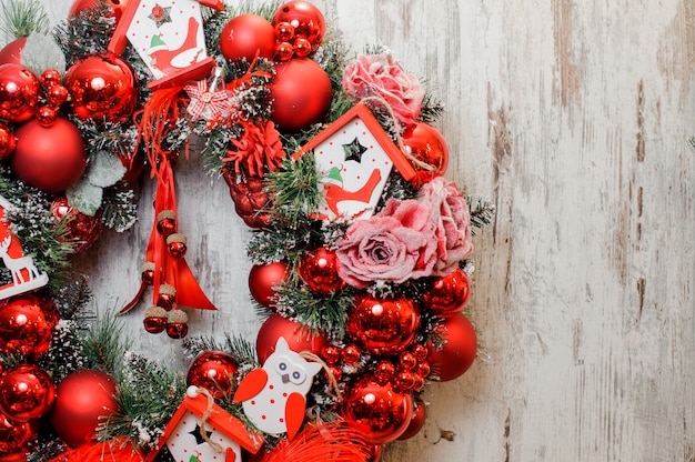 Guirlanda de Natal decorada com bolas vermelhas, rosas e casas de brinquedo