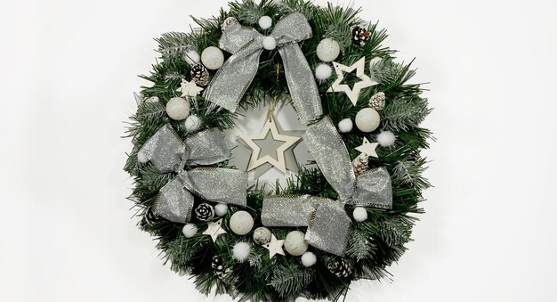 Guirlanda de natal decorando a porta da frente para as festas, feita de estrelas com arcos de prata de abeto e