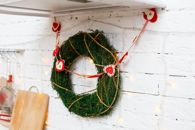 Guirlanda de Natal decorativa na porta com galhos. Decoração nas portas da frente no novo ano