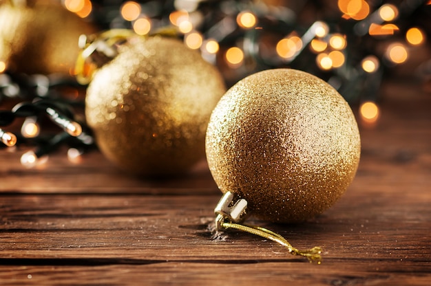 Guirlanda de Natal e bolas de ouro na mesa de madeira