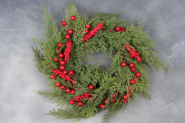 Guirlanda de Natal feita de galhos de pinheiro de aparência naturalista e decorada com frutas silvestres de inverno