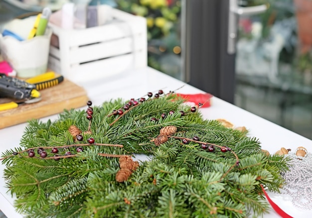 Guirlanda de Natal feita por florista profissional na mesa de uma floricultura