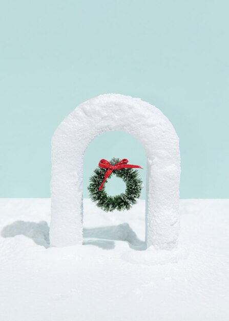 Guirlanda de natal no portão coberto de neve no fundo azul