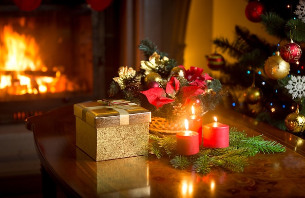Guirlanda decorativa de Natal com velas vermelhas acesas na mesa