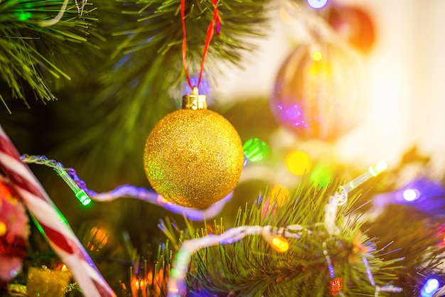 La guirnalda y una decoración en el árbol de Navidad en el fondo soleado