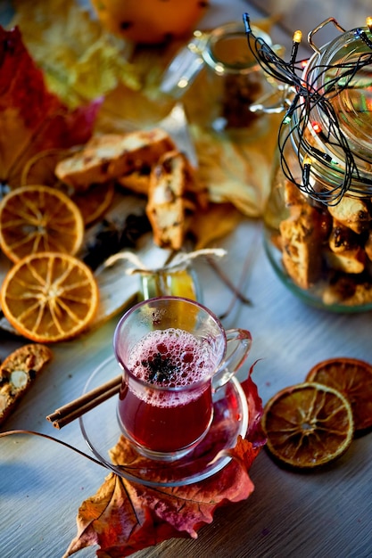 Guirnalda luminosa y hojas de otoñoVino caliente tinto Caliente velada romántica