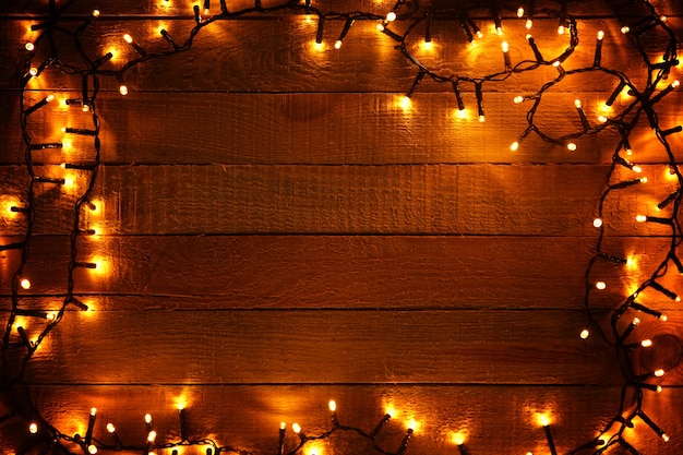 Guirnalda de Navidad eléctrica sobre fondo de madera