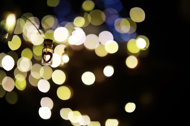 Guirnalda navideña de botellas de vidrio Concepto de año nuevo y navidad Una guirnalda de bombillas con una hermosa luz y bokeh