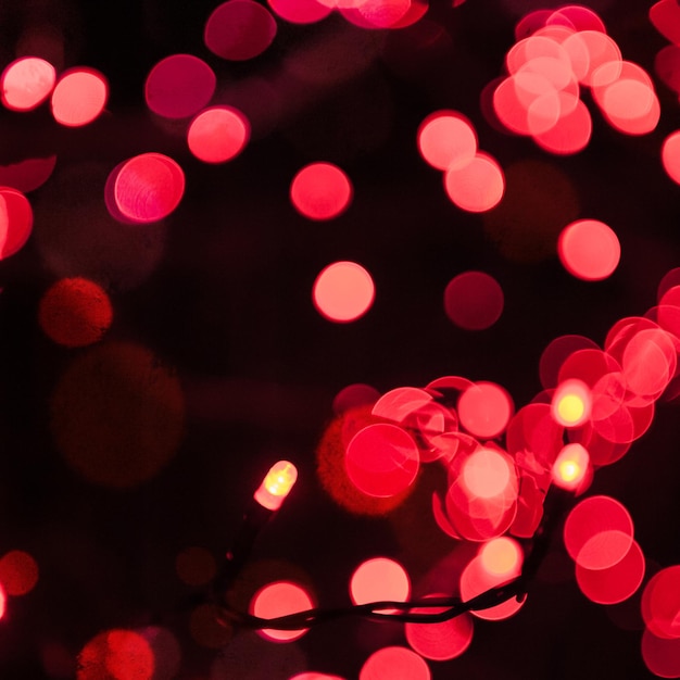 Guirnalda navideña con bulbos rojos. Fondo brillante con luces de colores