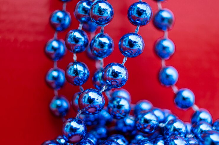 Foto guirnalda de perlas de navidad azul sobre fondo rojo abstracto