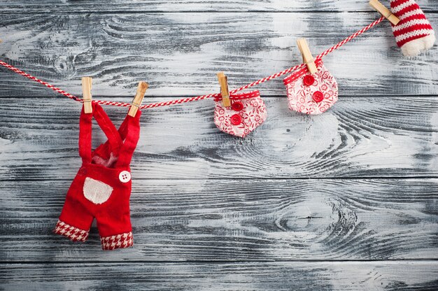 Guirnalda roja de Navidad con prendas de muñecas