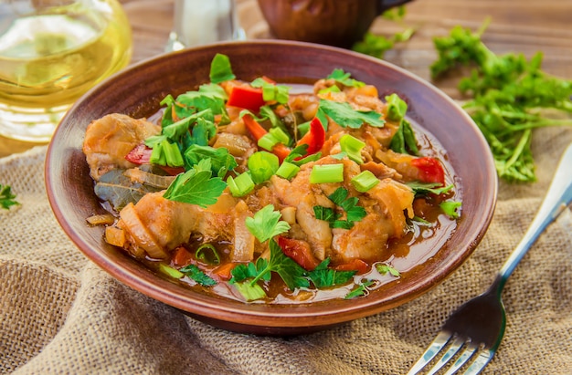 Guisado de galinha com cebola e vegetais no molho de tomate. chakhokhbili.