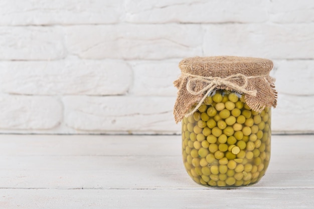 Guisantes en escabeche en un frasco Existencias de alimentos Vista superior Sobre un fondo de madera Espacio de copia