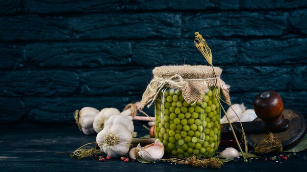 Guisantes en escabeche en un frasco Existencias de alimentos Vista superior Sobre un fondo de madera Espacio de copia