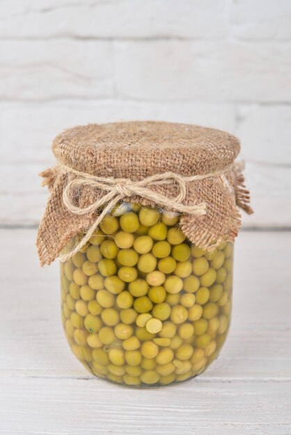 Guisantes en escabeche en un frasco Existencias de alimentos Vista superior Sobre un fondo de madera Espacio de copia