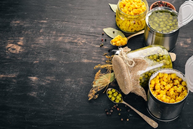 Guisantes marinados y maíz en un frasco Existencias de alimentos Vista superior Sobre un fondo de madera Espacio de copia