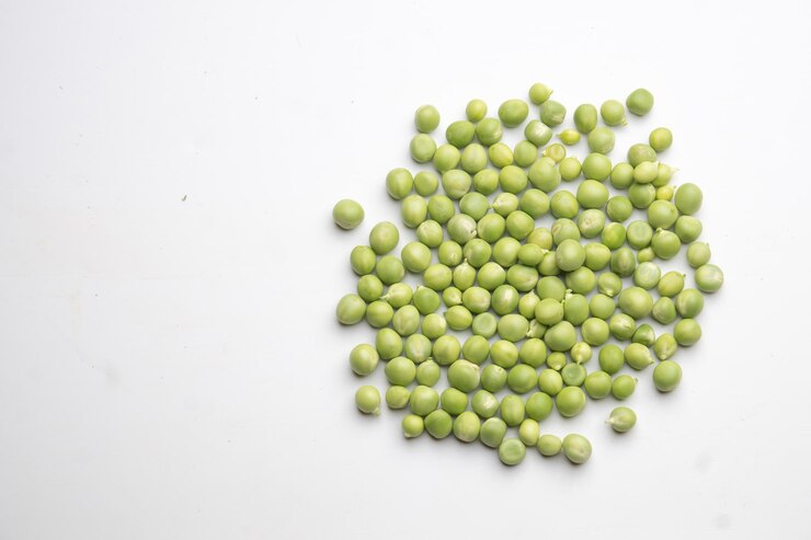 Unos guisantes verdes aislados sobre guisantes de fondo blanco en el centro