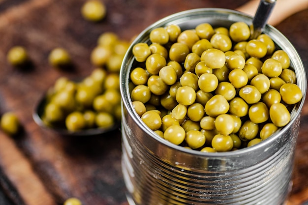 Guisantes verdes enlatados en una tabla para cortar