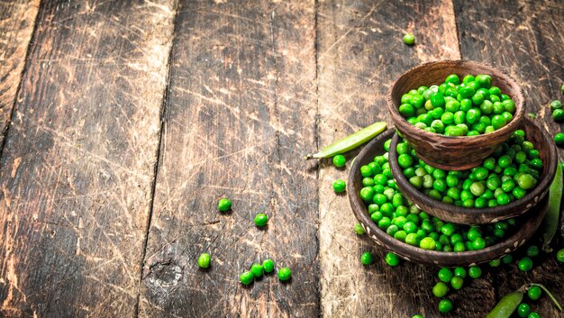 Guisantes verdes frescos en un bol. Sobre un fondo de madera.