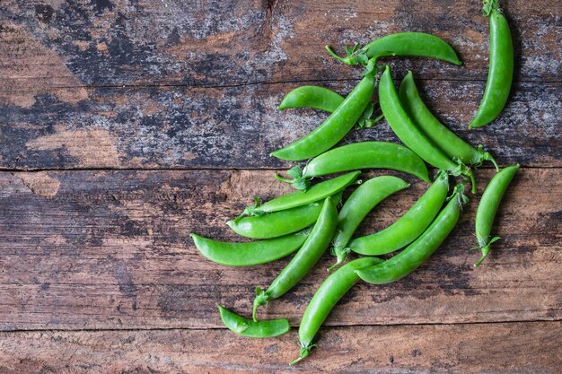 Guisantes verdes frescos en el fondo de madera